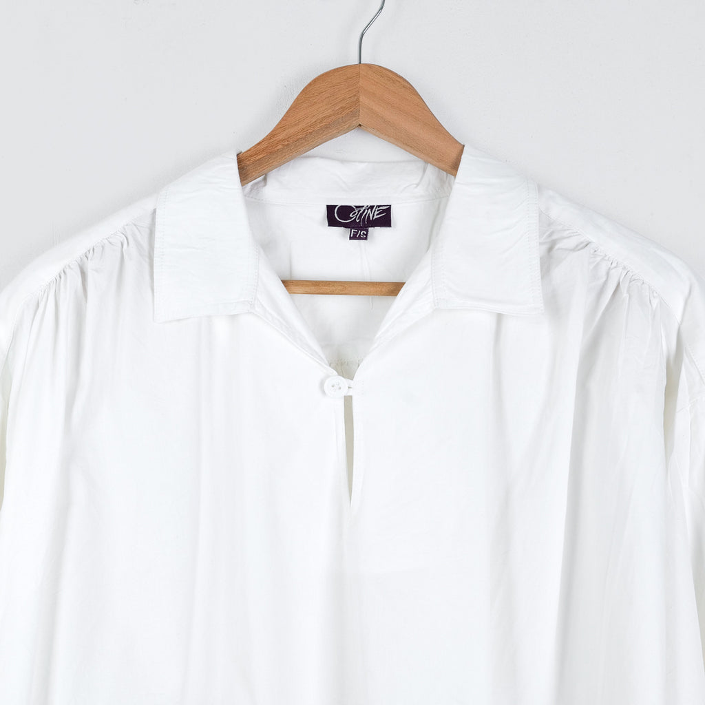 White Picasso shirt by Coline Diffusion on a hanger, gathered shoulders, one size