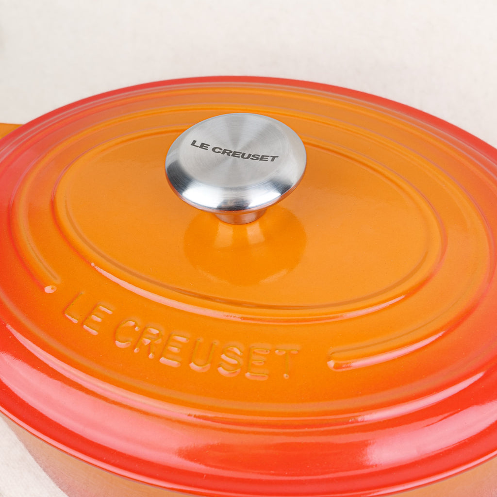 Gros plan sur le couvercle et son bouton inox d'une cocotte ovale Le Creuset Volcanique en fonte émaillée, fabrication française