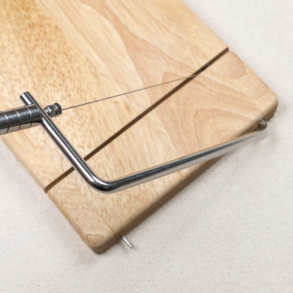 Wire cheese slicer on rubberwood board with adjustable wire, for cutting soft and semi-hard cheese after dinner