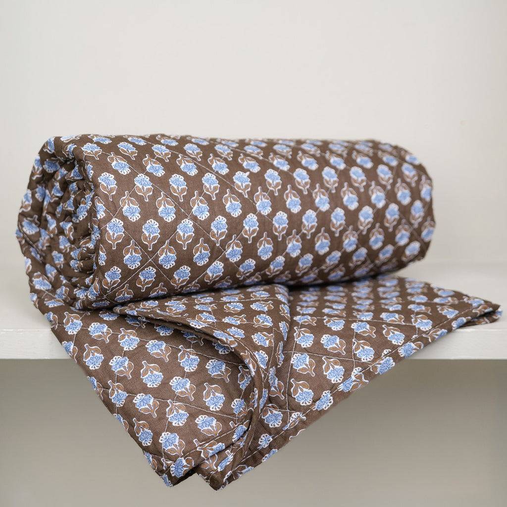 Brown quilt with blue flowers