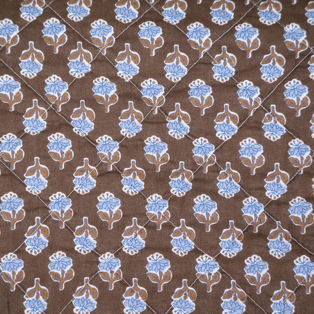 Brown quilt with blue flowers