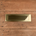 Brass letterbox plate with spring