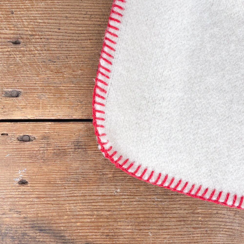 White wool throw with red stitching