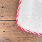 White wool throw with red stitching