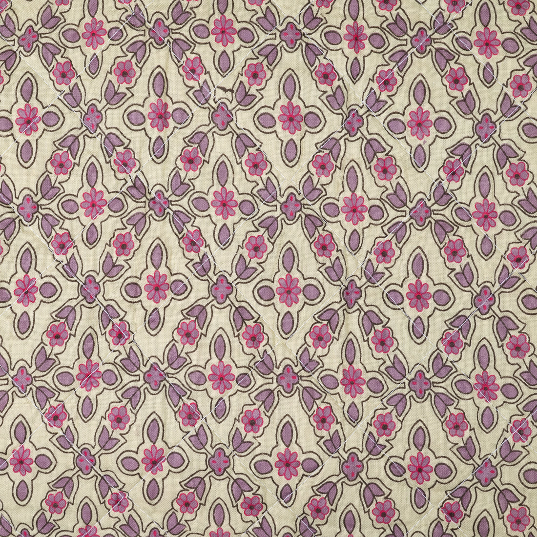 Gros plan sur le motif losanges fleuris rose et mauve du plaid coton matelassé Ib Laursen 130x180 cm