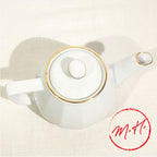 White porcelain teapot with gold rim
