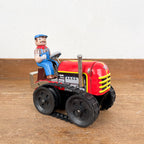 Tracteur mécanique rouge et son chauffeur
